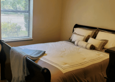 A serene bedroom scene showcasing a comfortable bed, a modern dresser, and a beautiful painting above the furniture.