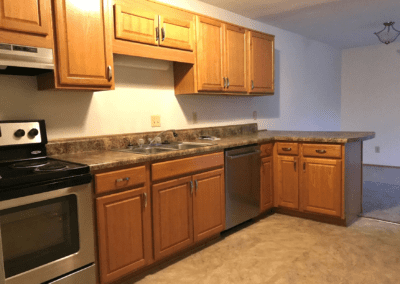 A modern kitchen featuring a sink, stove, and refrigerator, showcasing a clean and functional design.